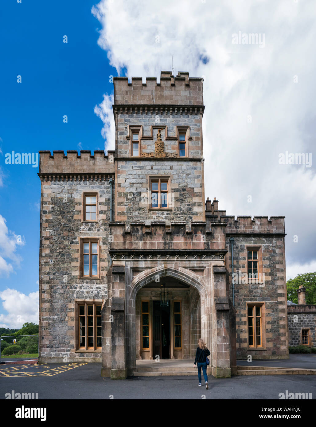 Tourist walks into Lews Castle a mock Tudor building built in 19th century as a private residence for Sir James Matheson, then owner of the island, wh Stock Photo