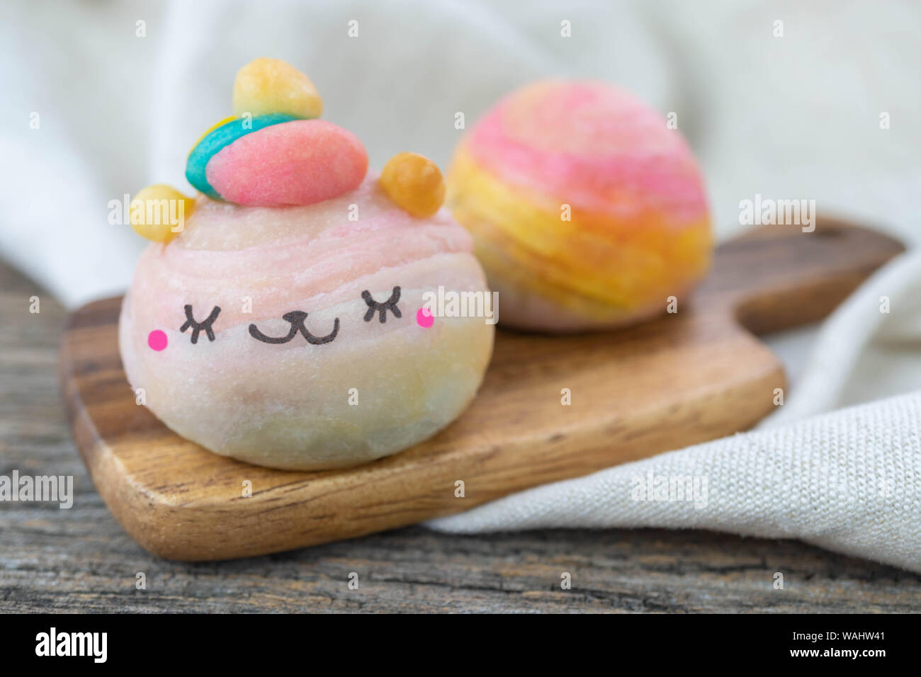 Cute Chinese Pastry or moon cake stuffed with salted egg yolk on wood plate Stock Photo