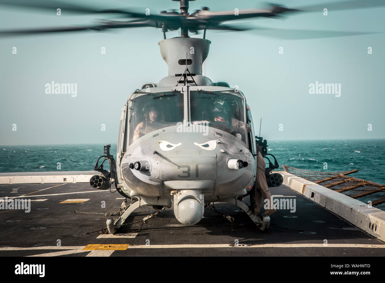 190815-M-QP663-1056 ARABIAN SEA (Aug. 15, 2019) Marines assigned to Marine Medium Tiltrotor Squadron (VMM) 163 (Reinforced), 11th Marine Expeditionary Unit (MEU), conduct pre-flight checks in a UH-1Y Venom aboard the amphibious transport dock ship USS John P. Murtha (LPD 26). The Boxer Amphibious Ready Group and 11th MEU are deployed to the U.S. 5th Fleet area of operations in support of naval operations to ensure maritime stability and security in the Central Region, connecting the Mediterranean and the Pacific through the Western Indian Ocean and three strategic choke points. (U.S. Marine Co Stock Photo