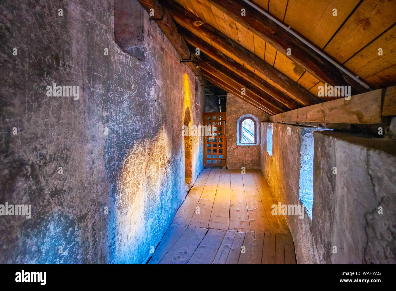SALZBURG, AUSTRIA - FEBRUARY 27, 2019: The covered corridor of medieval catacombs with low windows in St Peters cemetery, on February 27 in Salzburg Stock Photo