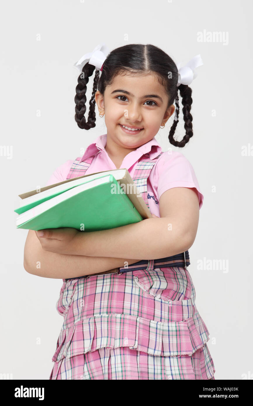 Schoolgirl standing and holding books Stock Photo - Alamy