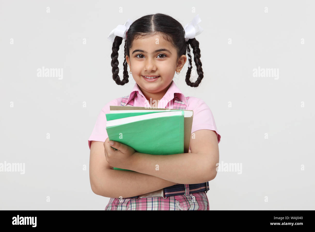 Indian schoolgirl standing and holding books Stock Photo - Alamy