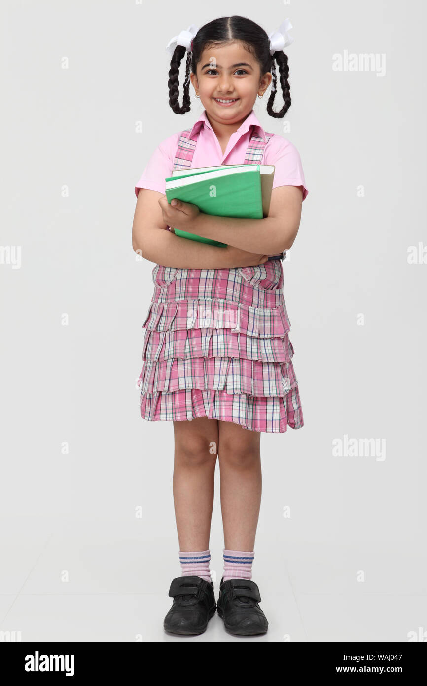 Schoolgirl standing and holding books Stock Photo - Alamy
