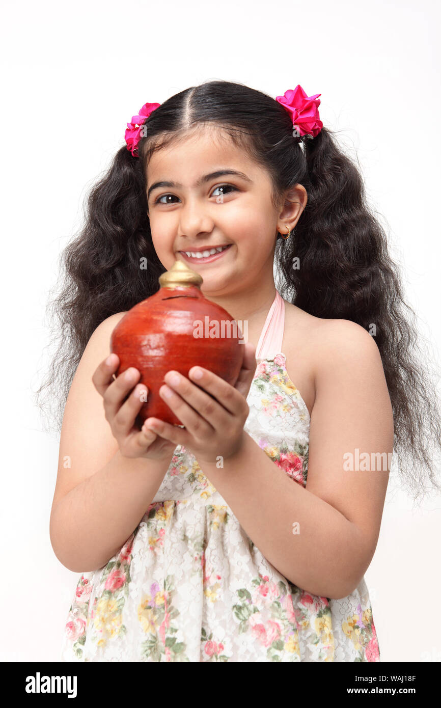 Girl holding a piggy bank and smiling Stock Photo - Alamy