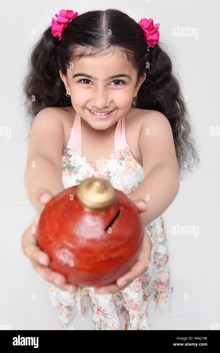 Indian girl holding piggy bank hi-res stock photography and images - Alamy