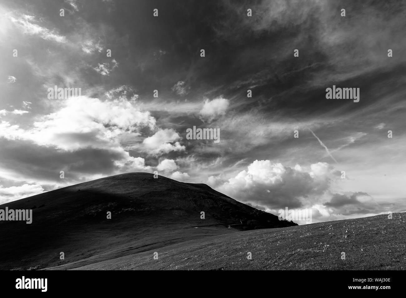 Mountain top under a deep sky, with white and fluffly clouds Stock Photo