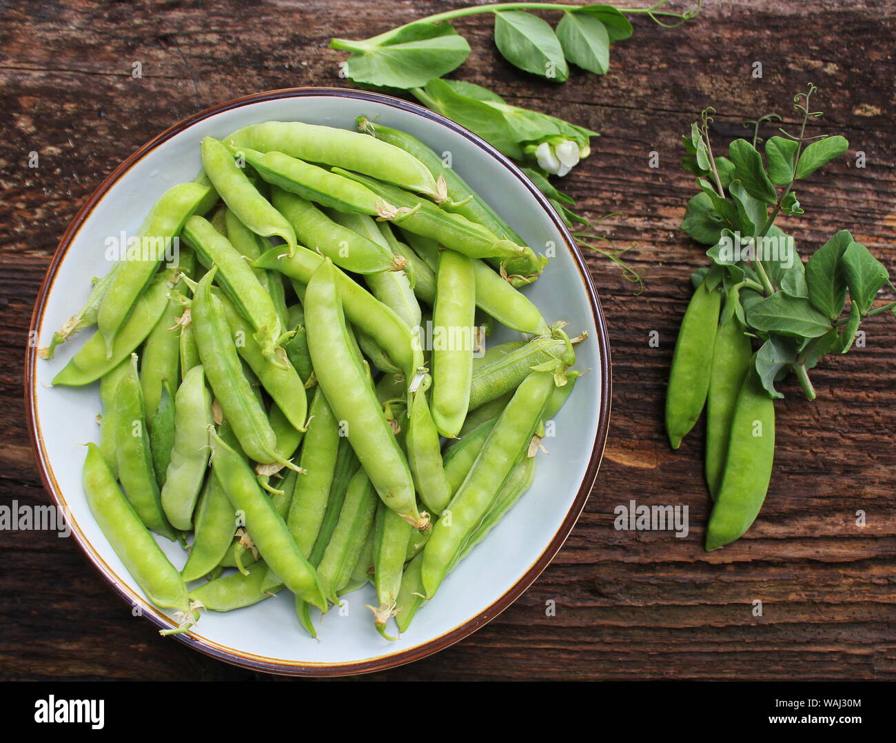 Green peas in bowl on wooden table background. Top view Stock Photo
