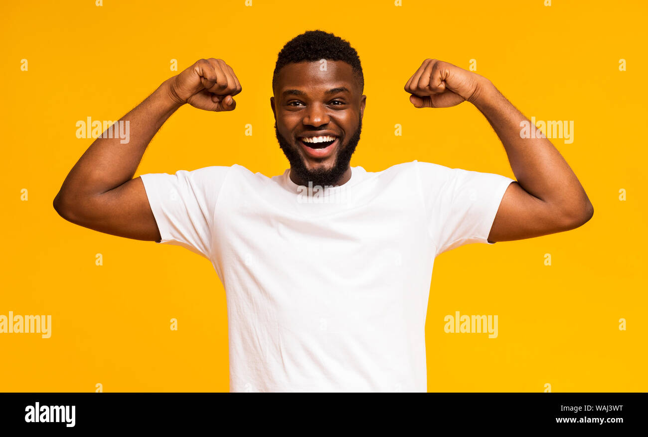 African american man smiling and showing biceps at camera Stock Photo