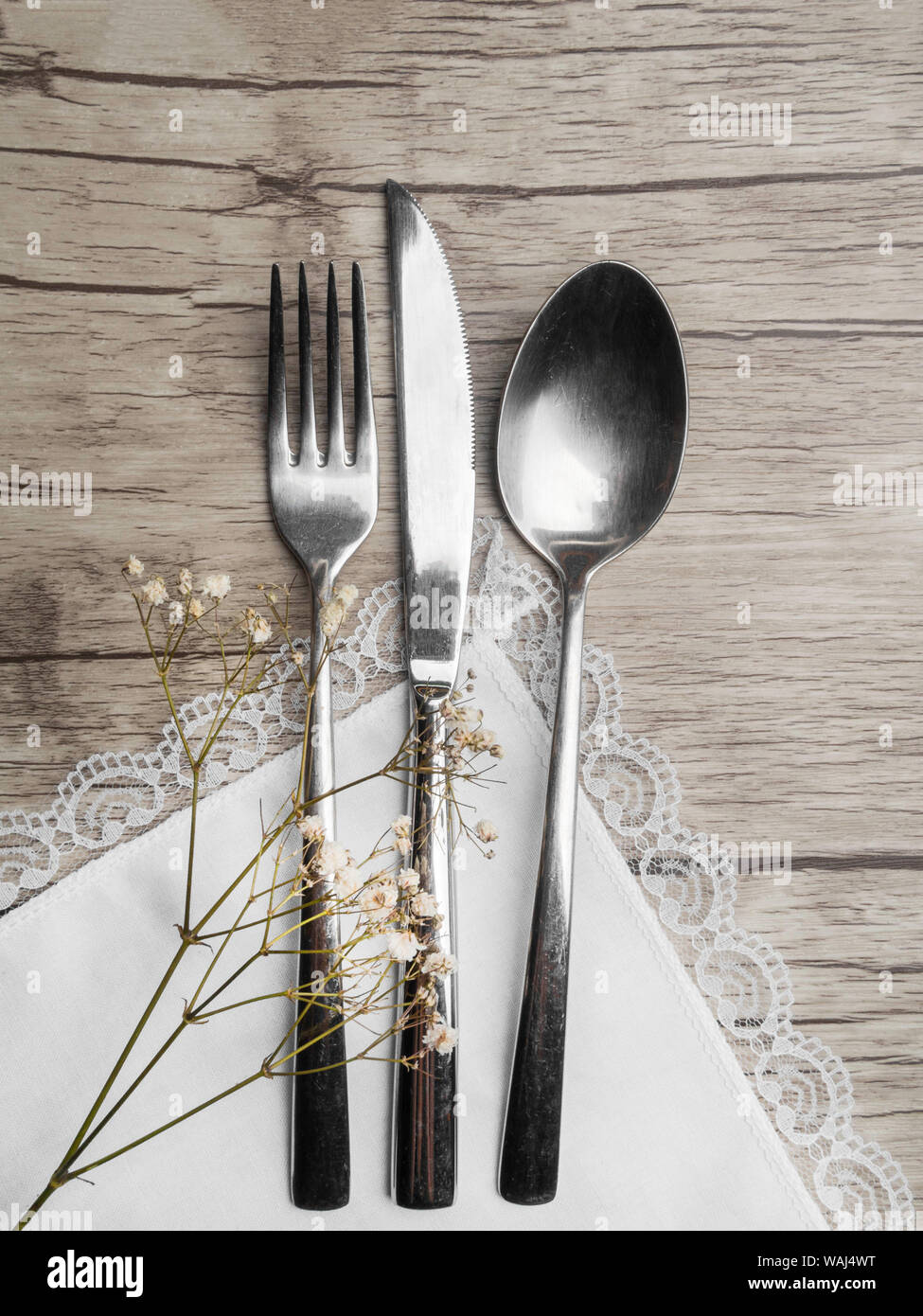 Light colored tableware set: vintage silverware on napkin and delicate ...