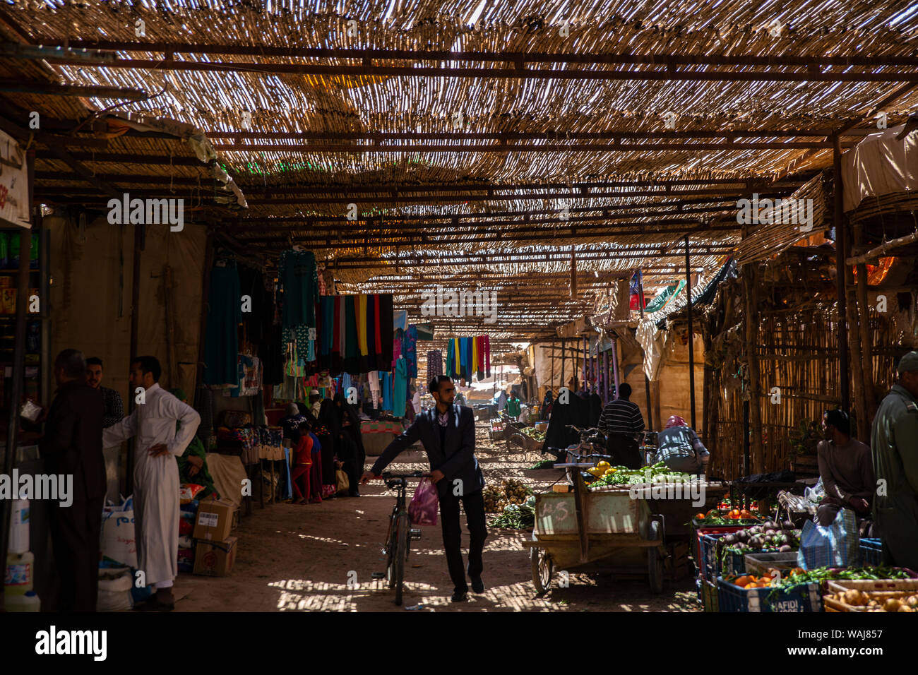 Merzougha, Erg Chebbi, Sahara Desert, Morocco. Man walking his bike through a souk market Stock Photo