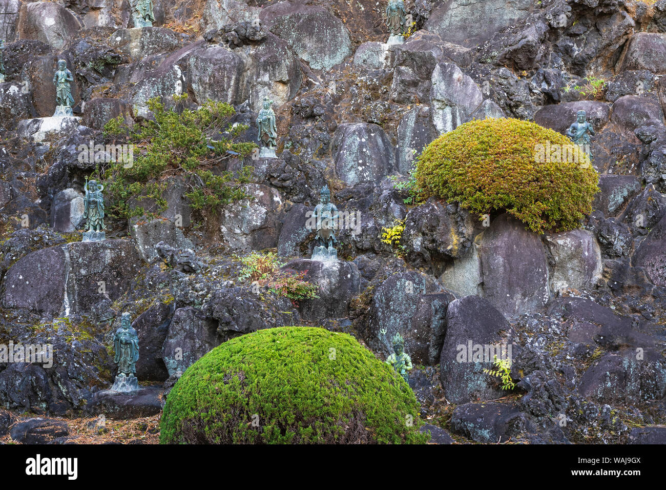 Rock wall of God statues lining a garden of Narita Temple Stock Photo