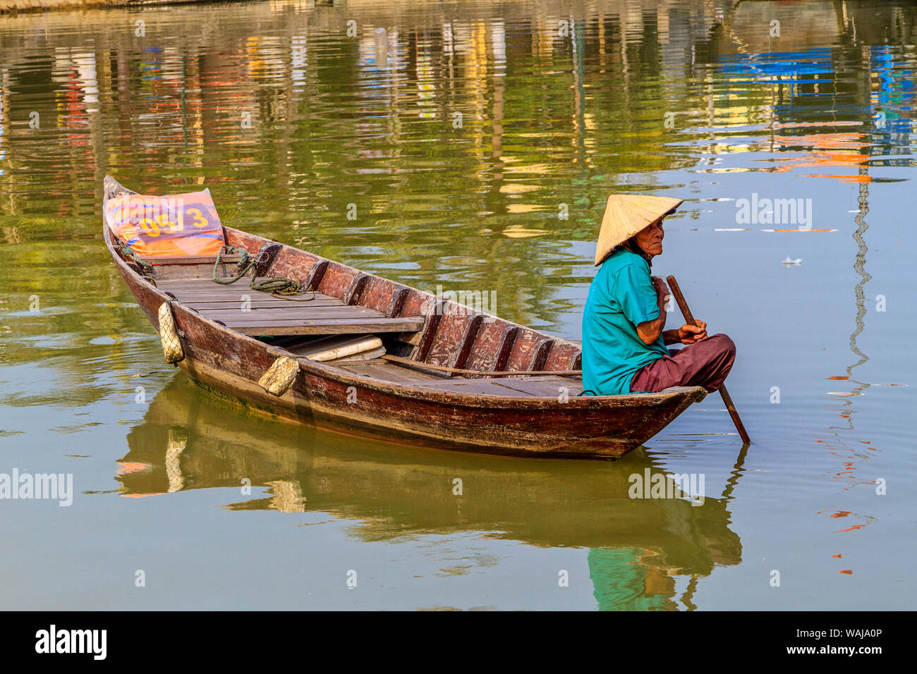 Hoi An, Vietnam. Elderly woman wearing Vietnamese cone hat in traditional boat on the Thu Bon River. (Editorial Use Only) Stock Photo