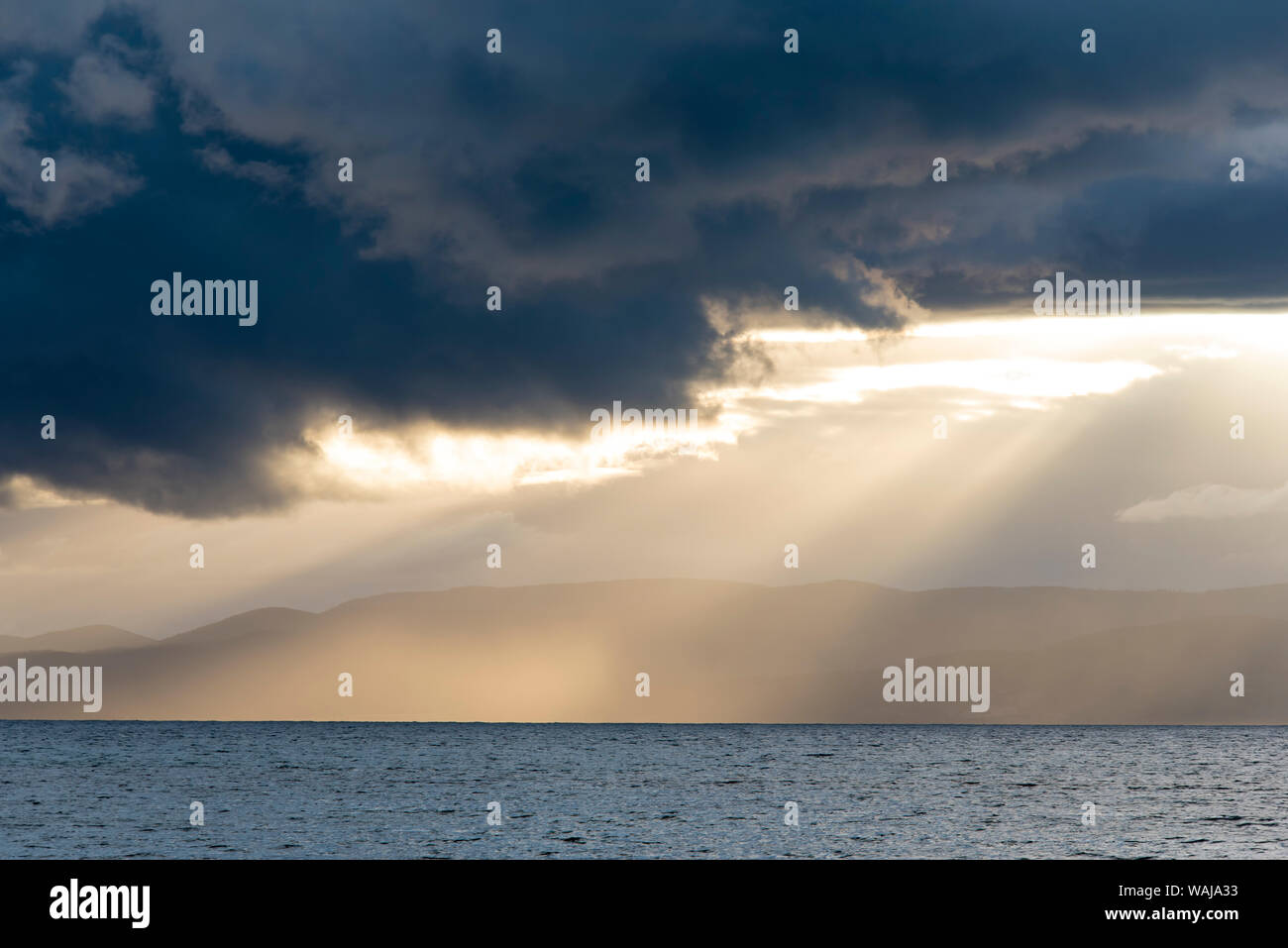 Australia, Tasmania, Freycinet National Park Morning light breaks through dark clouds Stock Photo