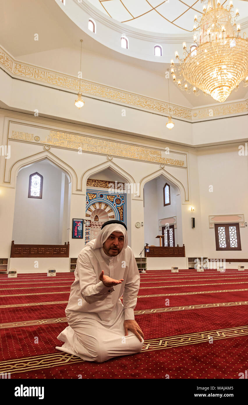 Dubai, UAE. Guide in a traditional Arab mens robe and headdress, talks about his Muslim religion in the mosque that is part of the Sheikh Mohammed Centre for Cultural Understanding. (MR, PR) Stock Photo