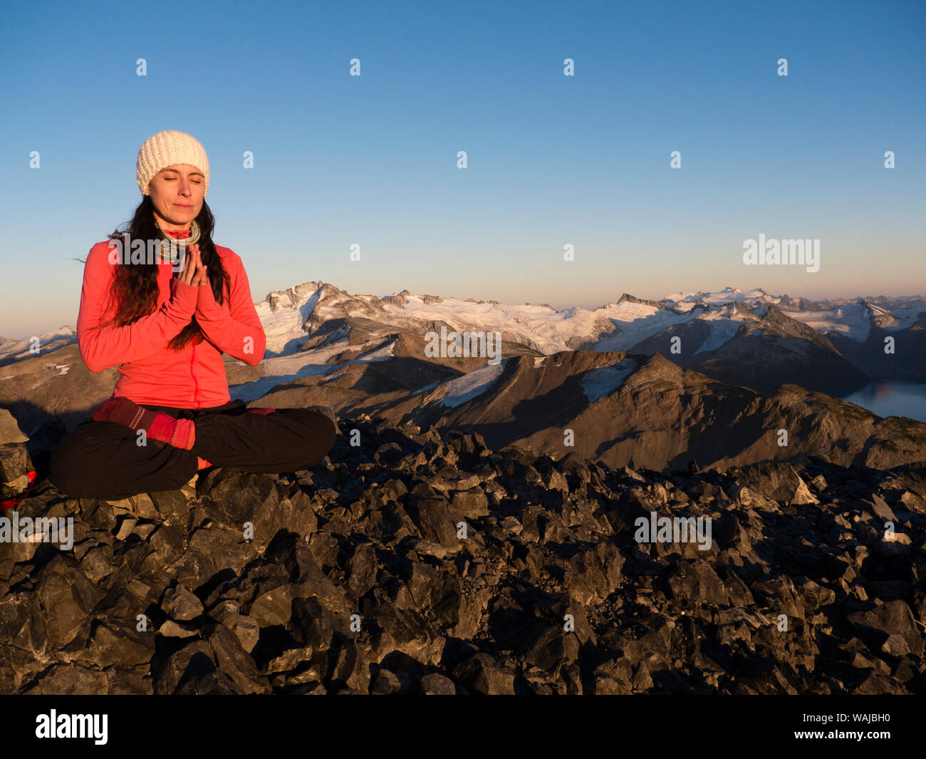 Woman on top of Black Tusk in lotus position, meditating in Garibaldi Provincial Park, British Columbia, Canada (MR) Stock Photo