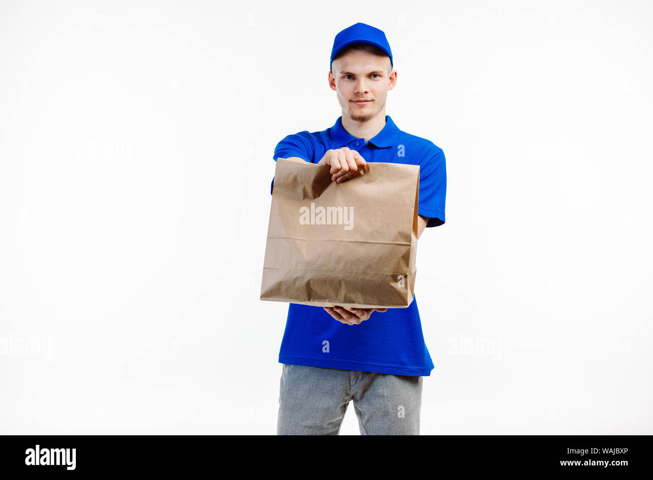 Food delivery coming at your place when you see a courier giving you a big paper bag with your order. Stock Photo