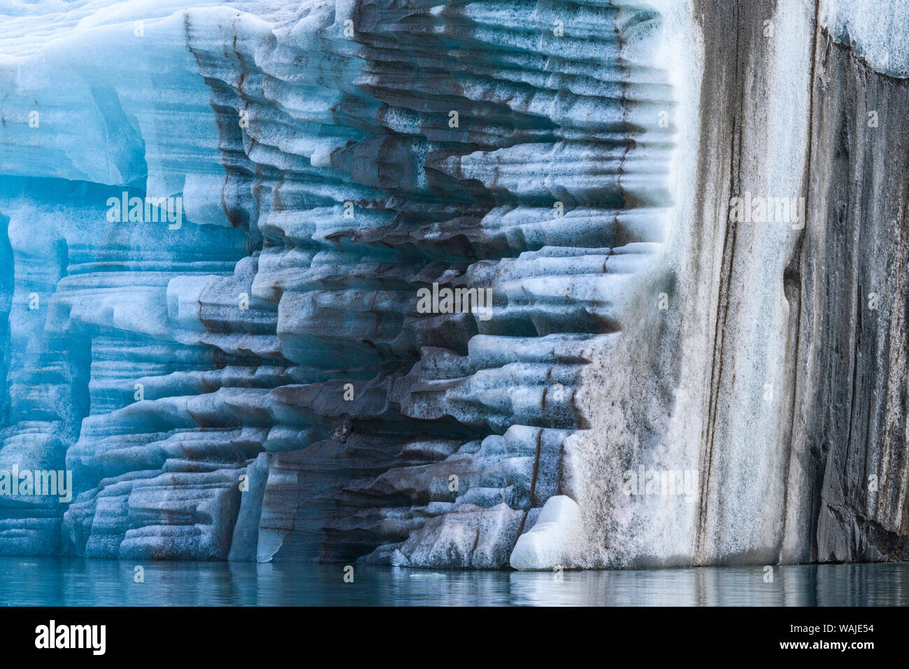 Norway, Svalbard, Spitsbergen. Large piece of glacial ice flipped over with moraine remnants. Stock Photo