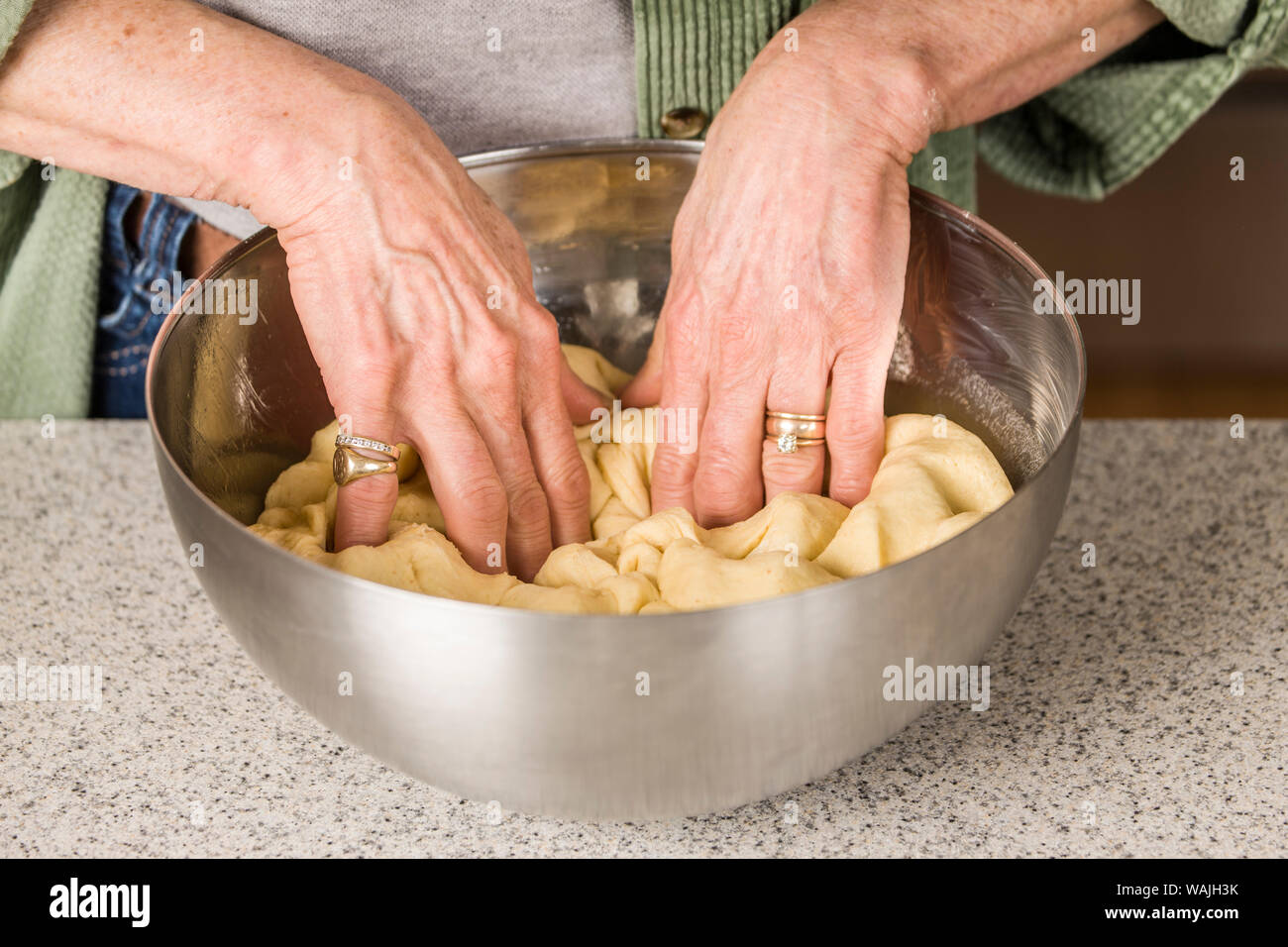 Woman punching down Monkey Bread dough, prior to forming it into balls. (MR) Stock Photo