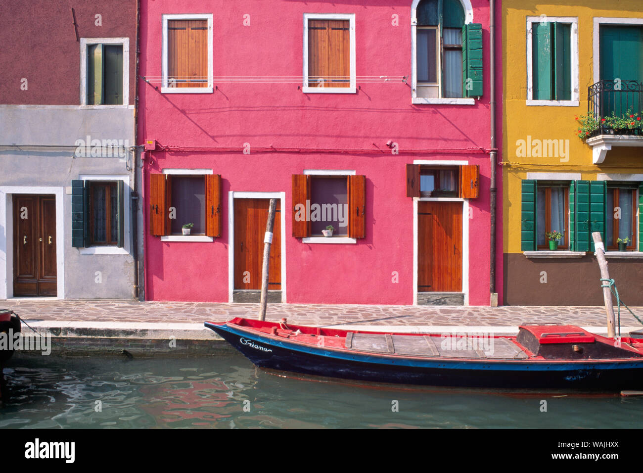 Italy, Burano. Colorful house exteriors and boat in canal. Credit as: Jim Nilsen / Jaynes Gallery / DanitaDelimont.com Stock Photo