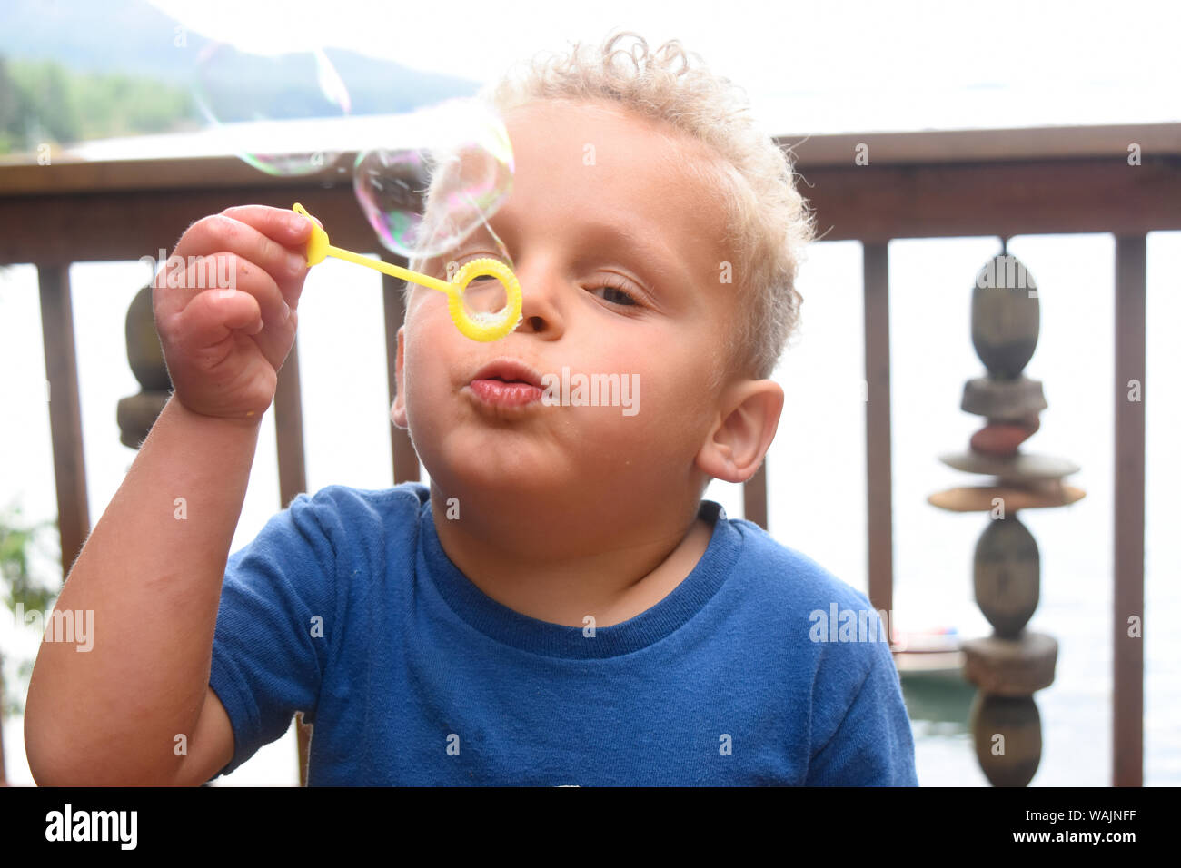 3 year old boy blowing bubbles. (MR) Stock Photo