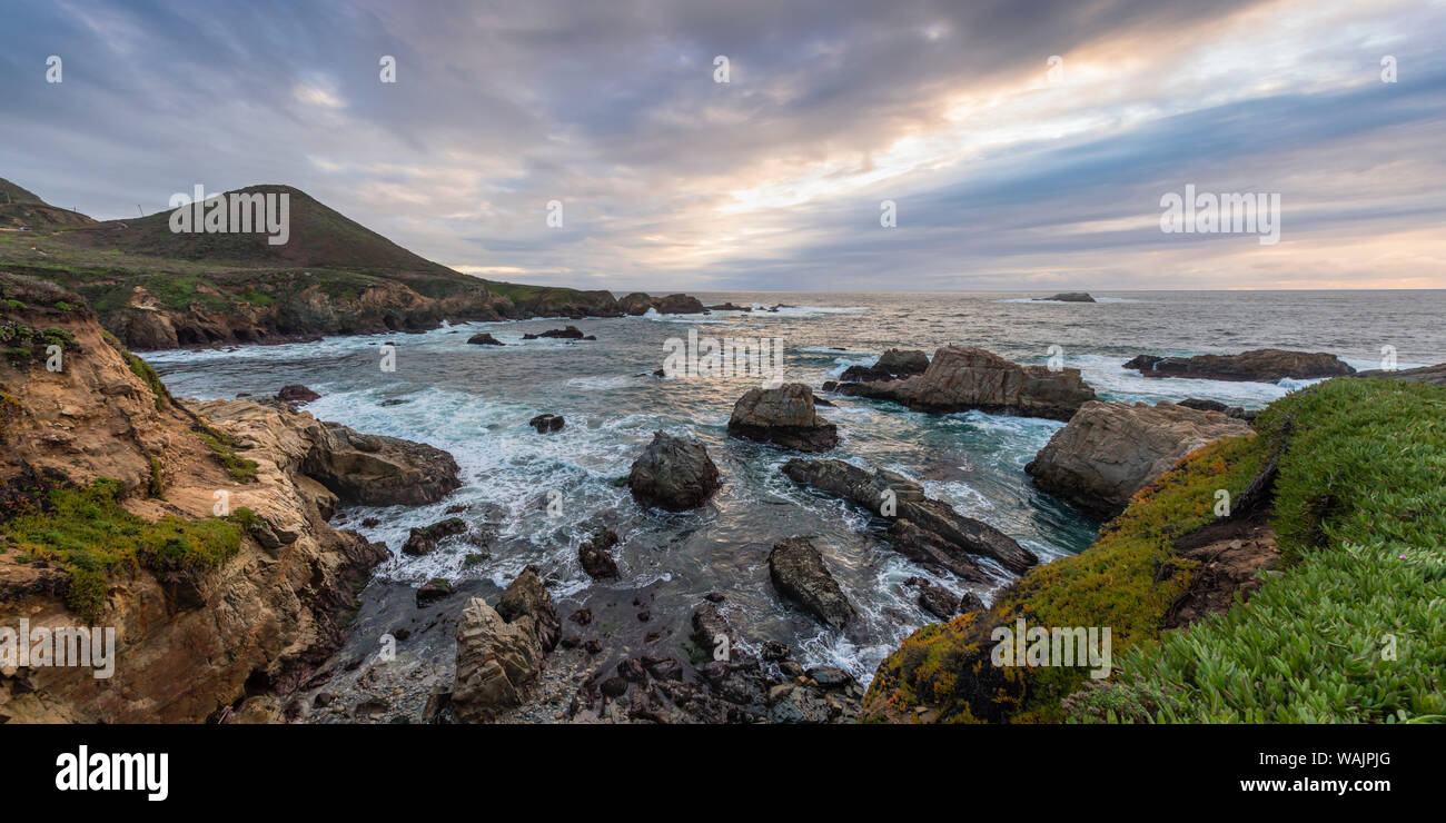 Cove of rocks and waves along Big Sur coastline with stormy skies Stock Photo