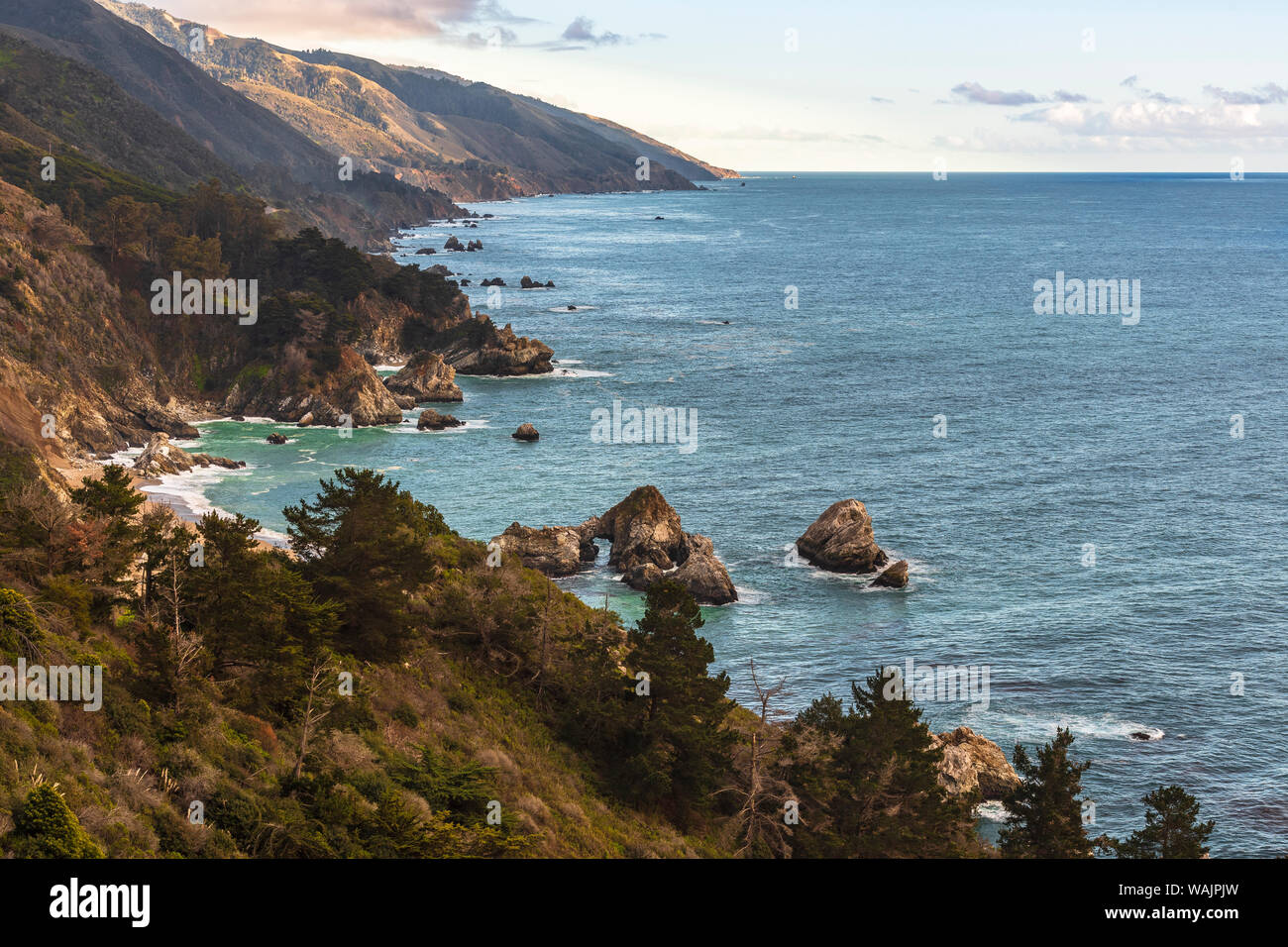 View south of Big Sur coastline with little arch rock in Ocean waters Stock Photo