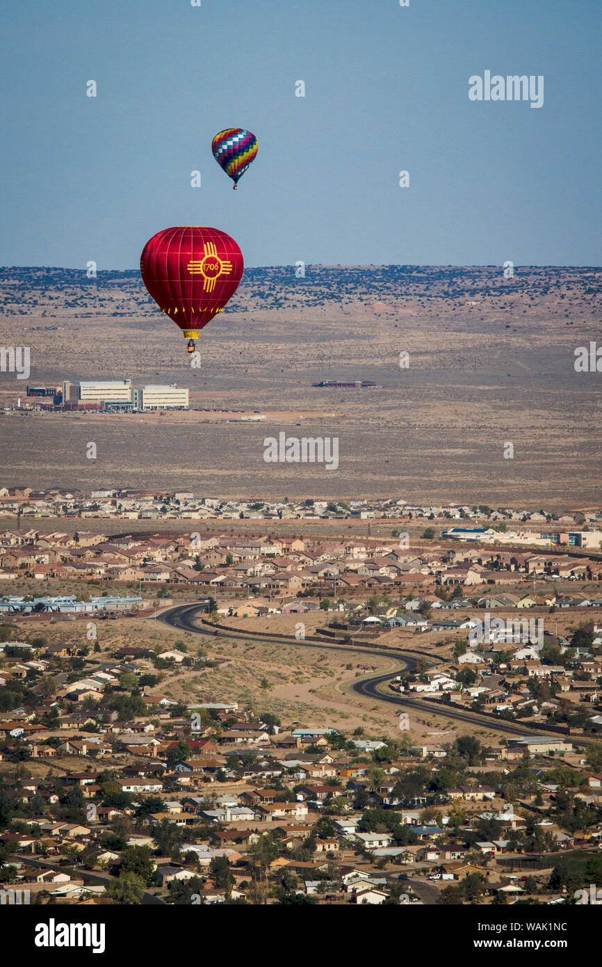 USA, New Mexico. Two balloons floating over homes in Albuquerque as part of the International Balloon Fiesta. Stock Photo