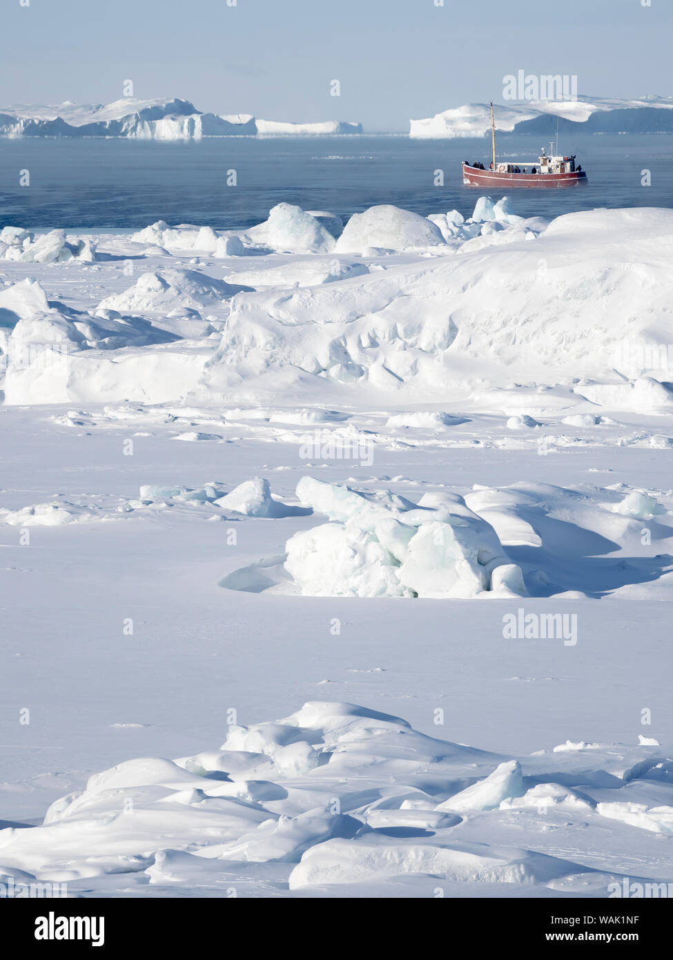 Boat on frozen Disko Bay with icebergs at the Ilulissat Icefjord, listed as UNESCO World Heritage Site. Greenland. (Editorial Use Only) Stock Photo