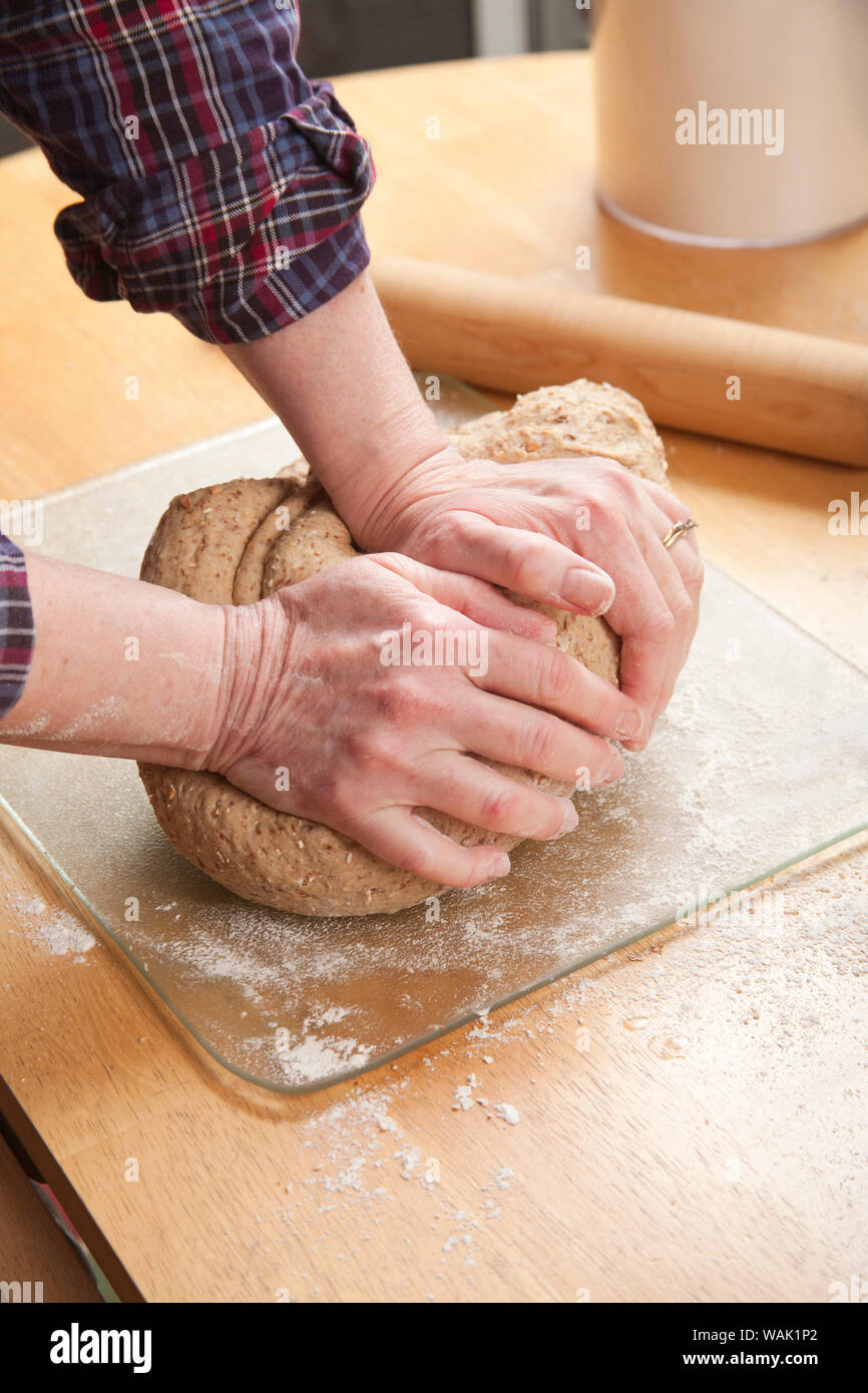 Woman kneading a multi-loaf multigrain bread dough. (MR) Stock Photo