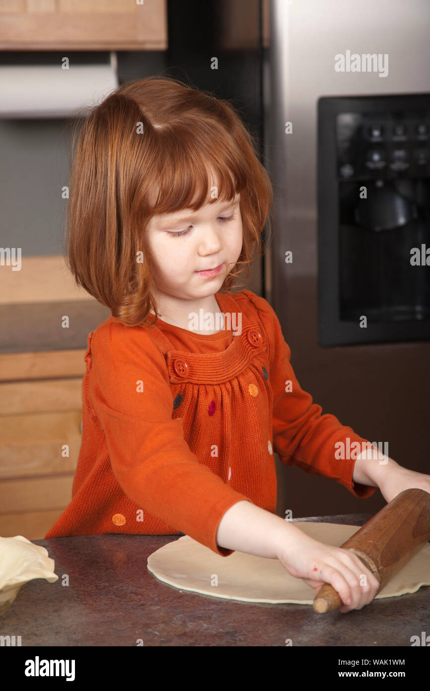 Girl rolling pie dough. (MR, PR) Stock Photo
