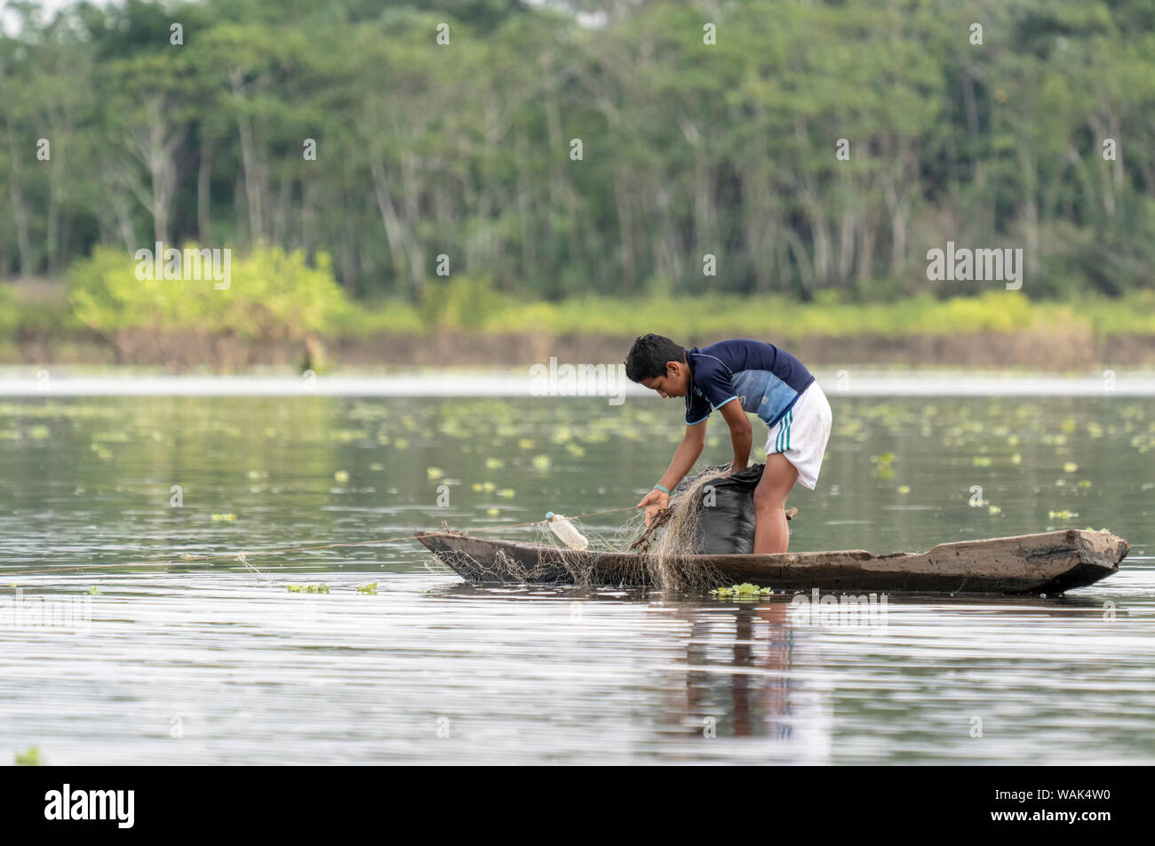 Pacaya Samiria Reserve, Peru. Young boy checking his fishing nets in the Ucayali River in the Amazon basin. (Editorial Use Only) Stock Photo
