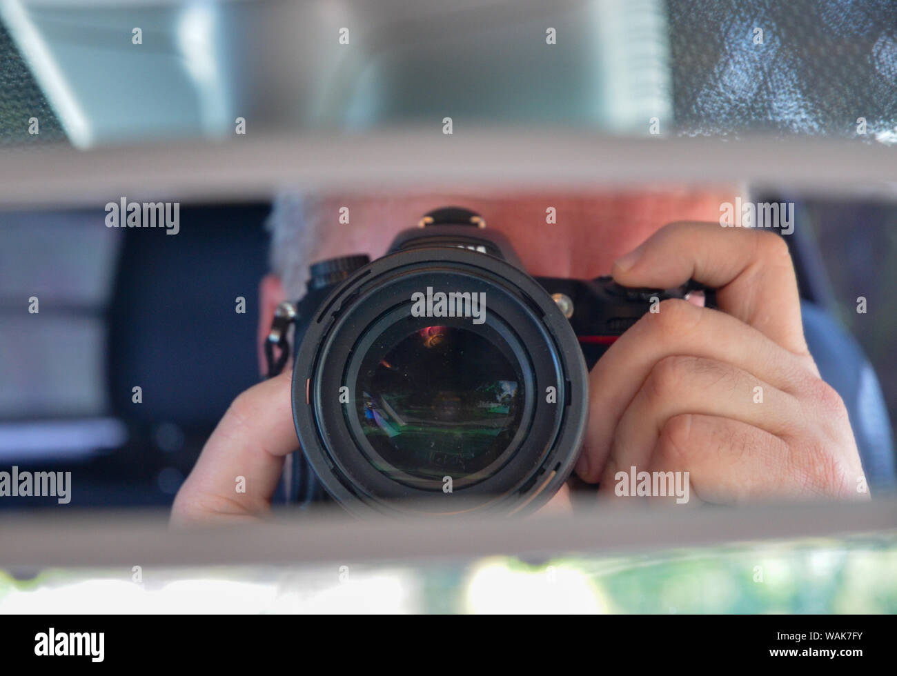 Photographer reflection in car rear view mirror Stock Photo