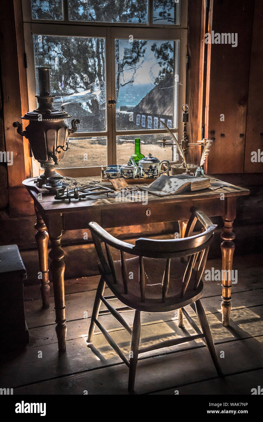 Old vintage desk with old desk accessories, against a window with a view of  the ocean Stock Photo - Alamy