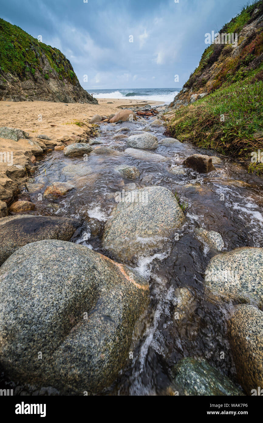 Stream flowing over rocks into the Pacific Ocean at Garrapata Beach, California Stock Photo