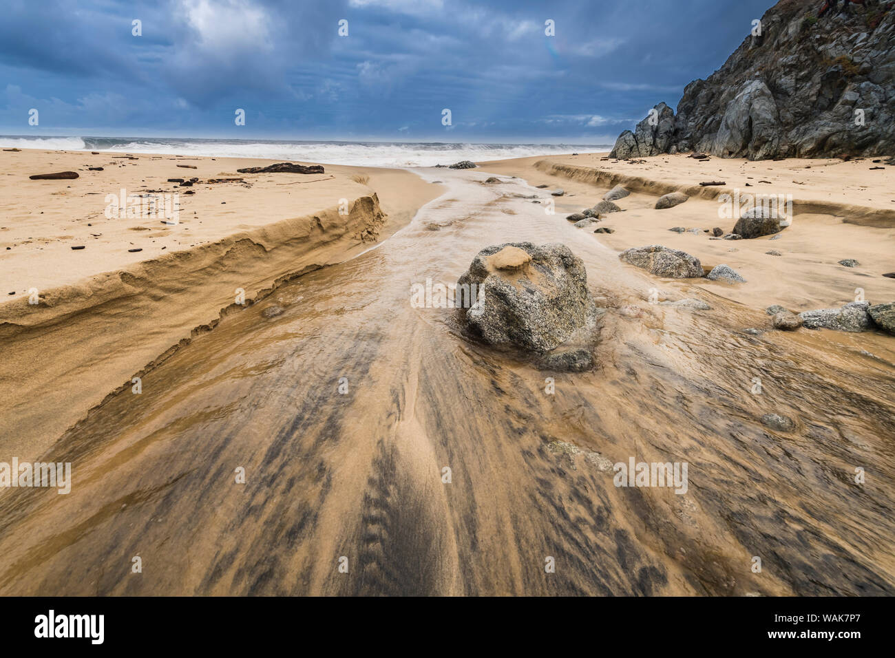 Stream flowing over a rock into the Pacific Ocean at Garrapata Beach, California Stock Photo