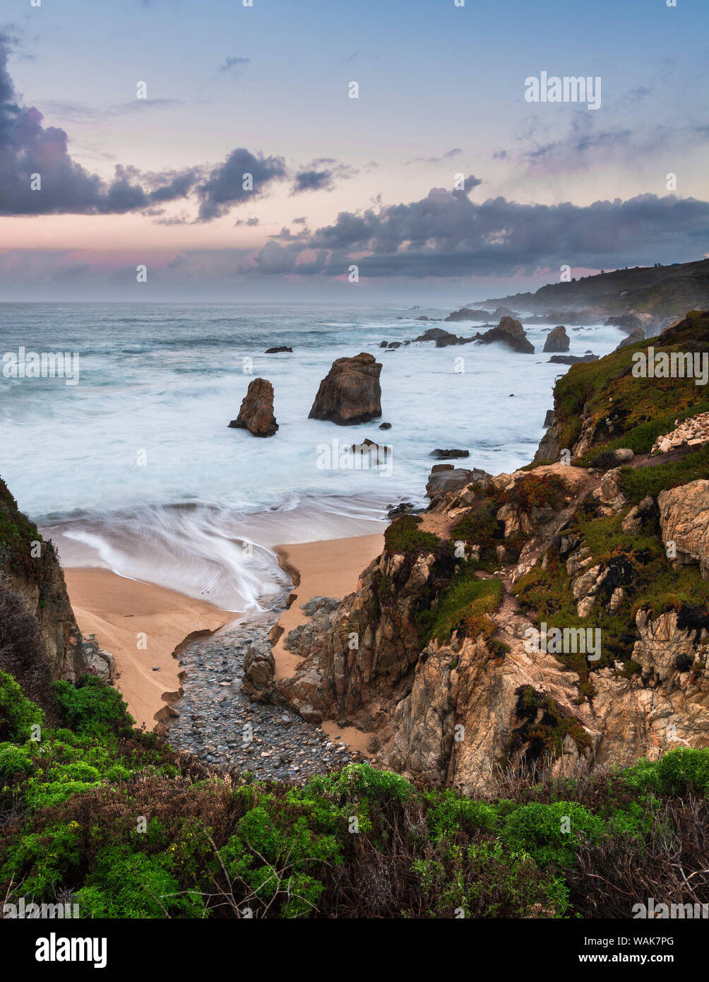 Stream flowing into the Pacific Ocean at Soberanes Point with the coastline in view Stock Photo