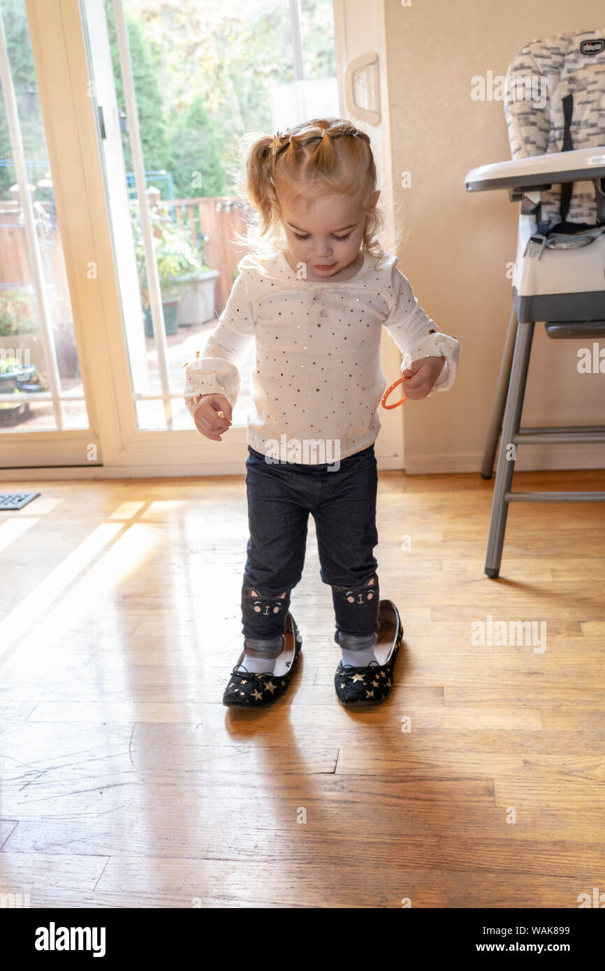 2 year old trying to walk in her mother's shoes. (MR,PR) Stock Photo