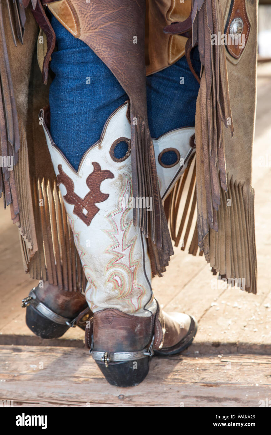 Horse drive in winter on Hideout Ranch, Shell, Wyoming. Cowgirl standing in doorway of old log cabin. (MR) Stock Photo