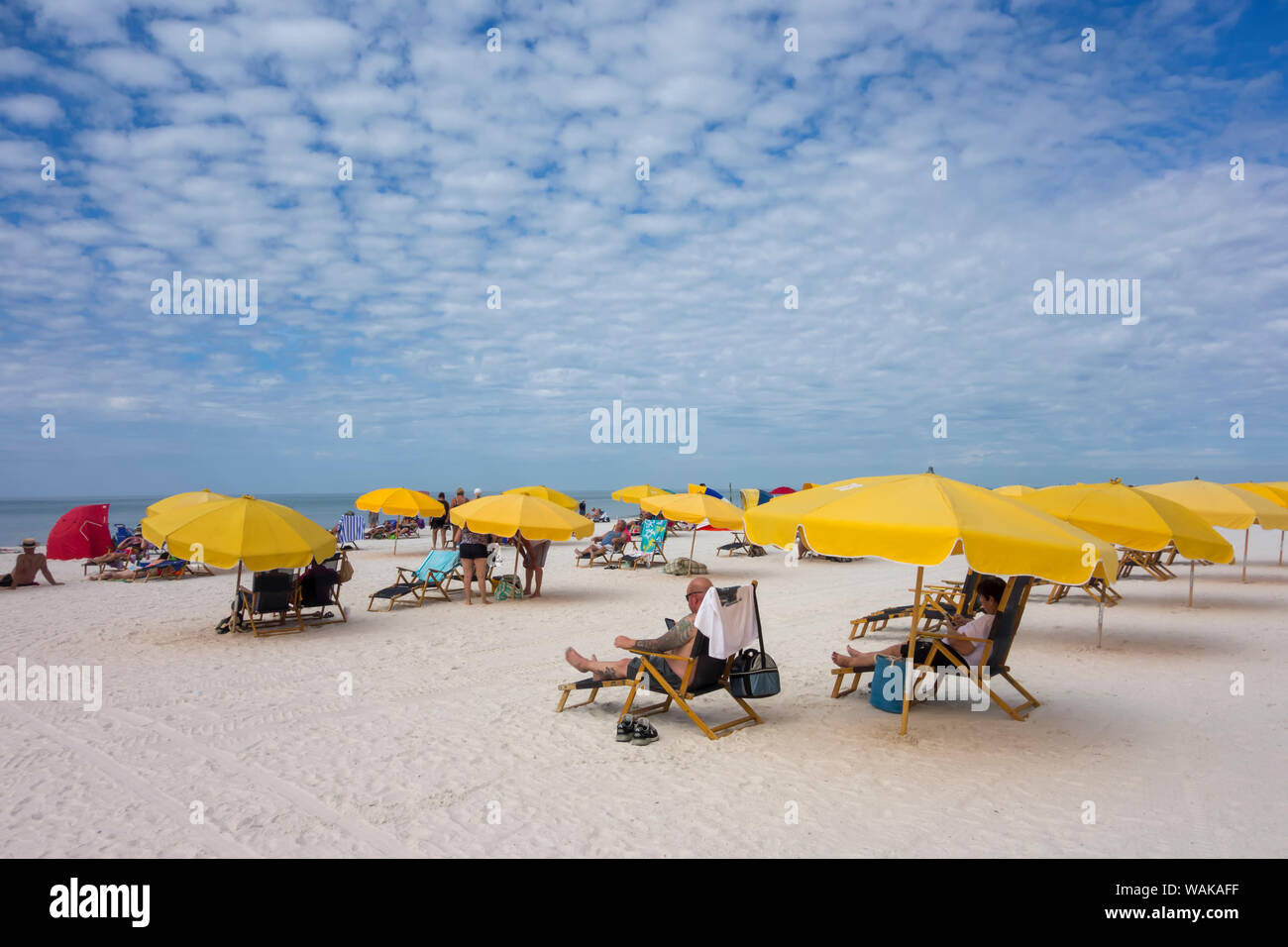 People sitting on beach chairs under umbrellas relaxing on Clearwater