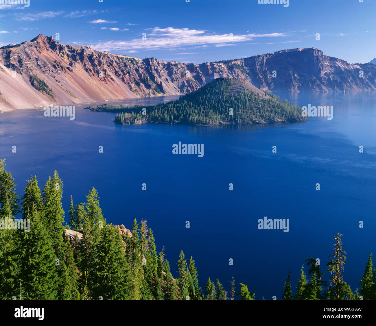 USA, Oregon. Crater Lake National Park, Crater Lake and Wizard Island with distant Hillman Peak (left) and Llao Rock (right). Stock Photo