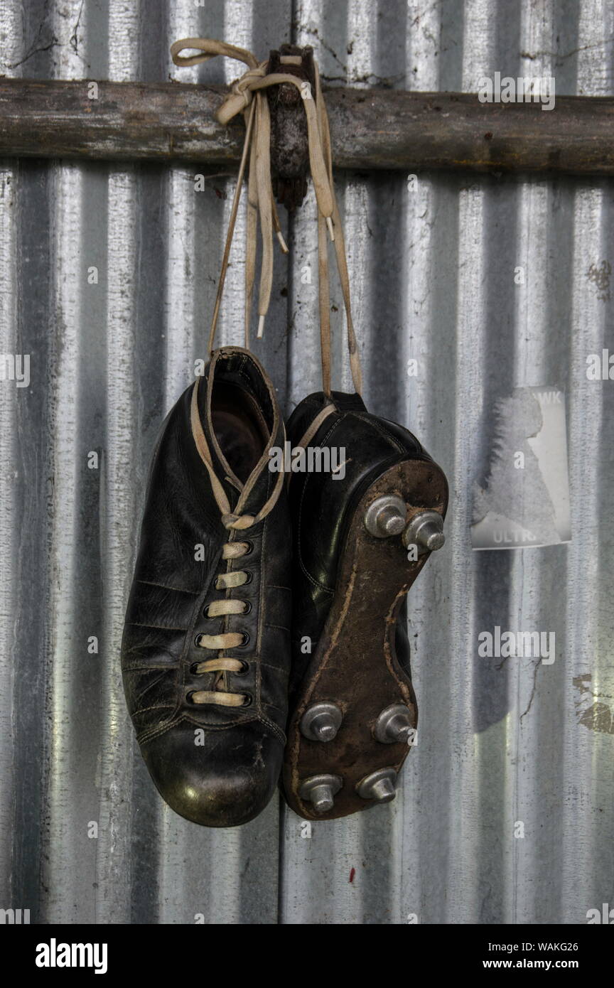 Antique leather football cleats, vintage boots, vintage leather football  shoes hanging in front of a corrugated tin fence Stock Photo - Alamy