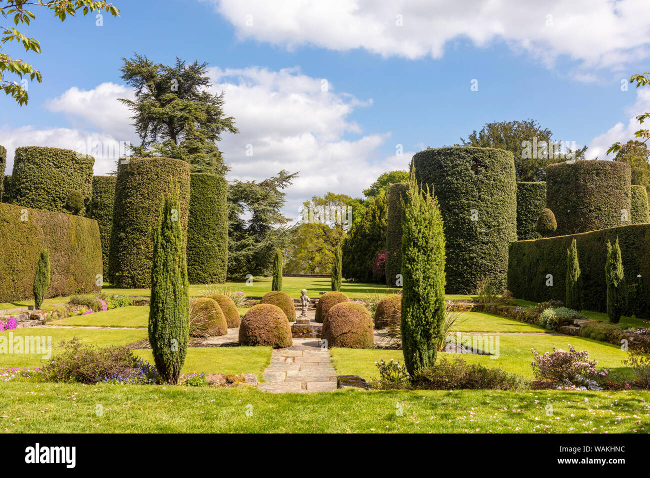 Formal garden with small statue and topiary shrubs. Stock Photo