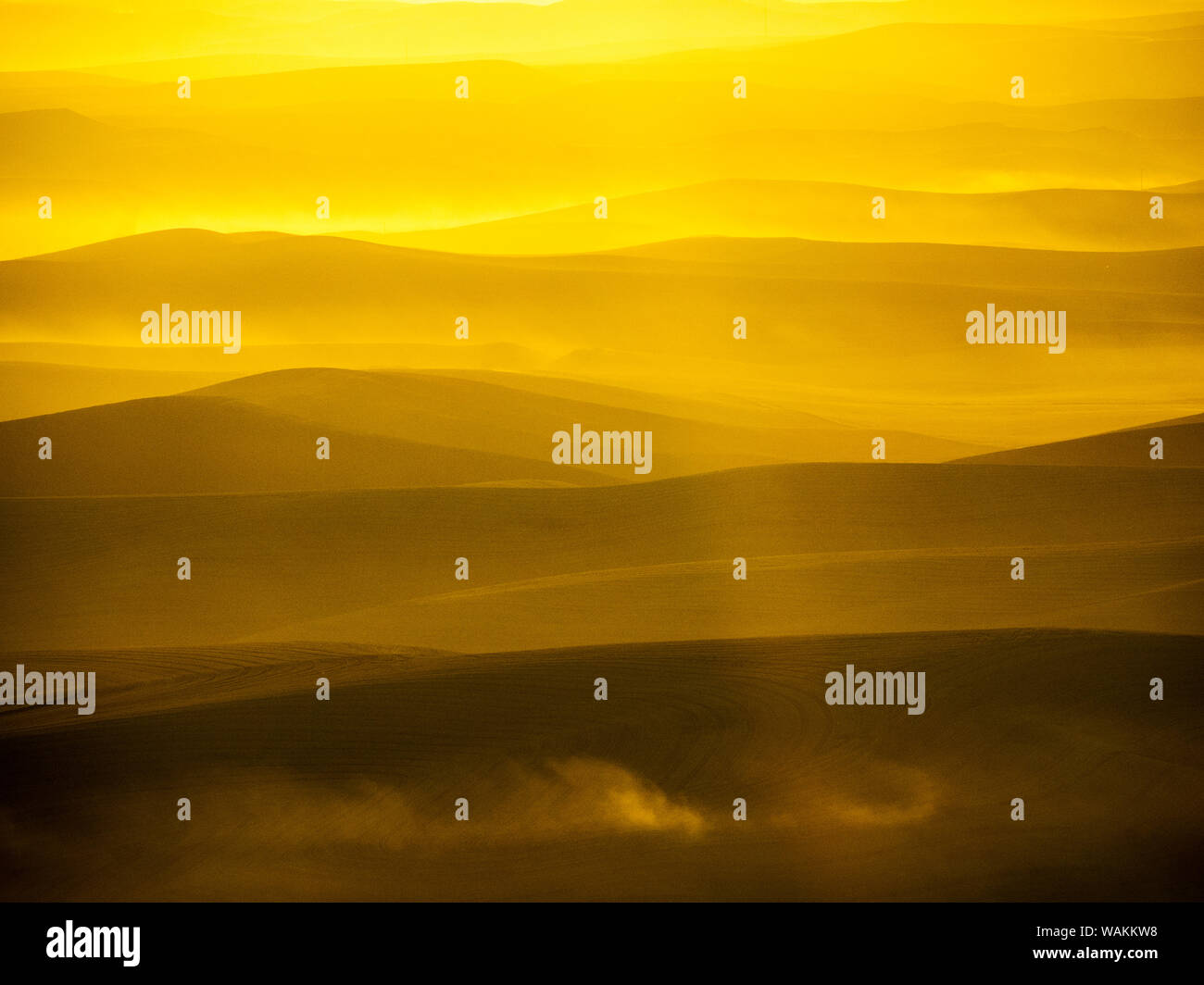 USA, Washington State, Palouse Region. Sunset over rolling hills with dust in the air Stock Photo