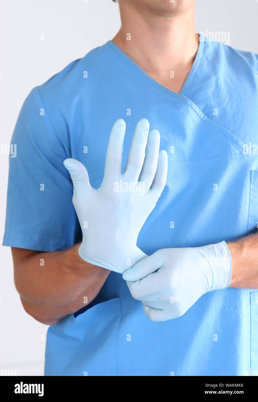 Doctor putting on sterile gloves isolated white Stock Photo Alamy