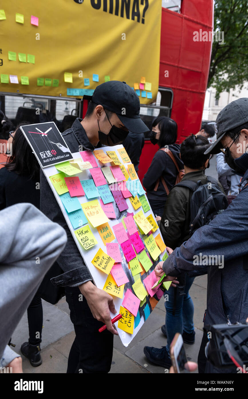 People protest outside the Chinese Embassy in London against the violent suppression of protests in Hong Kong. With a hired red London routemaster bus Stock Photo