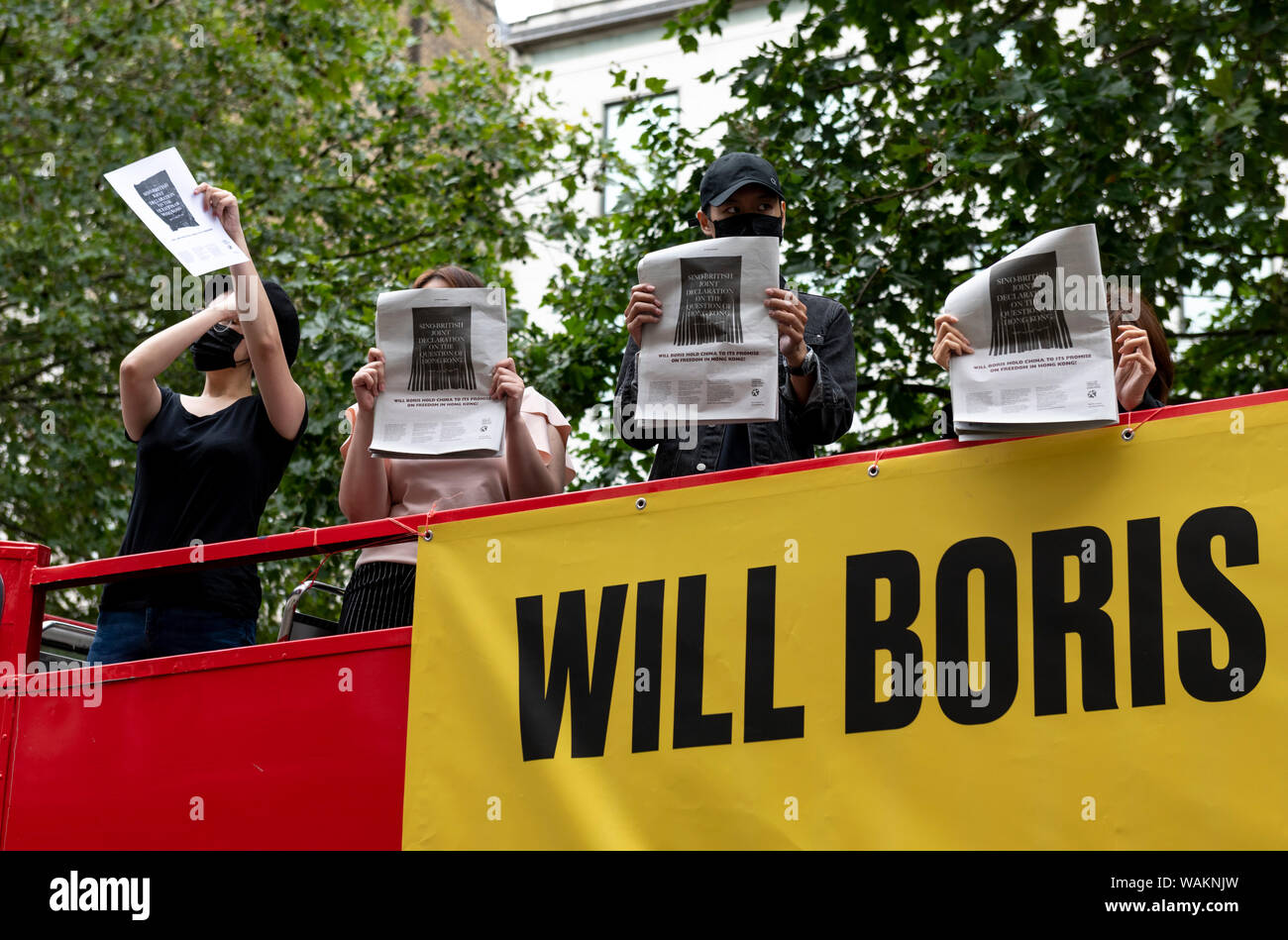 People protest outside the Chinese Embassy in London against the violent suppression of protests in Hong Kong holding copies of the internationally ru Stock Photo