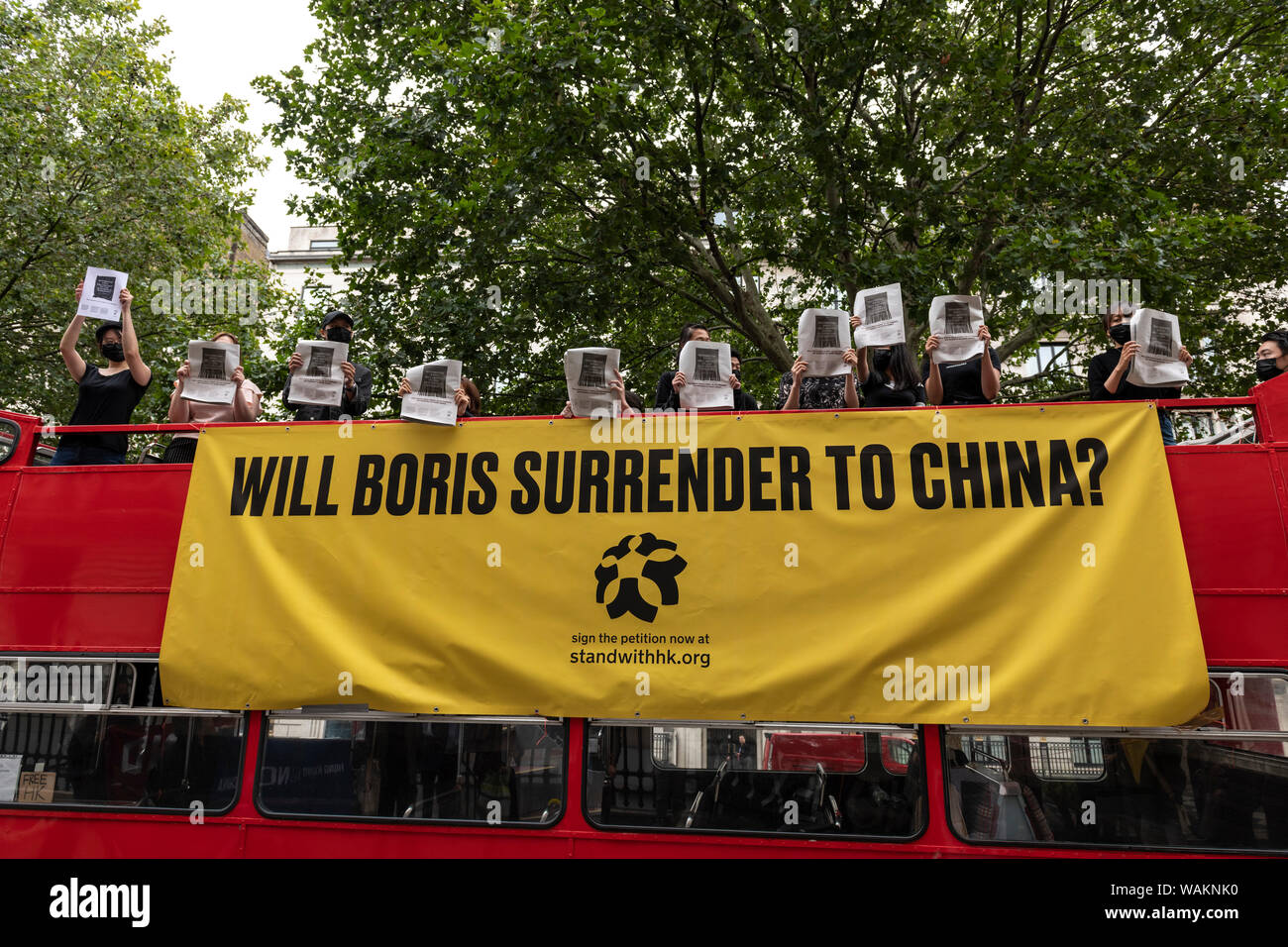 People protest outside the Chinese Embassy in London against the violent suppression of protests in Hong Kong holding copies of the internationally ru Stock Photo