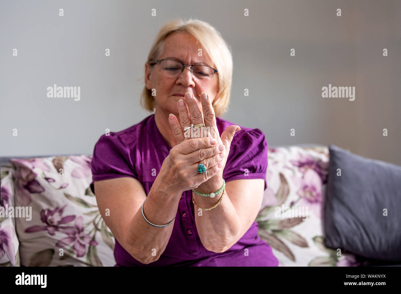 Elderly woman suffering from pain in hand, arthritis old person and senior woman female suffering from pain at home Stock Photo