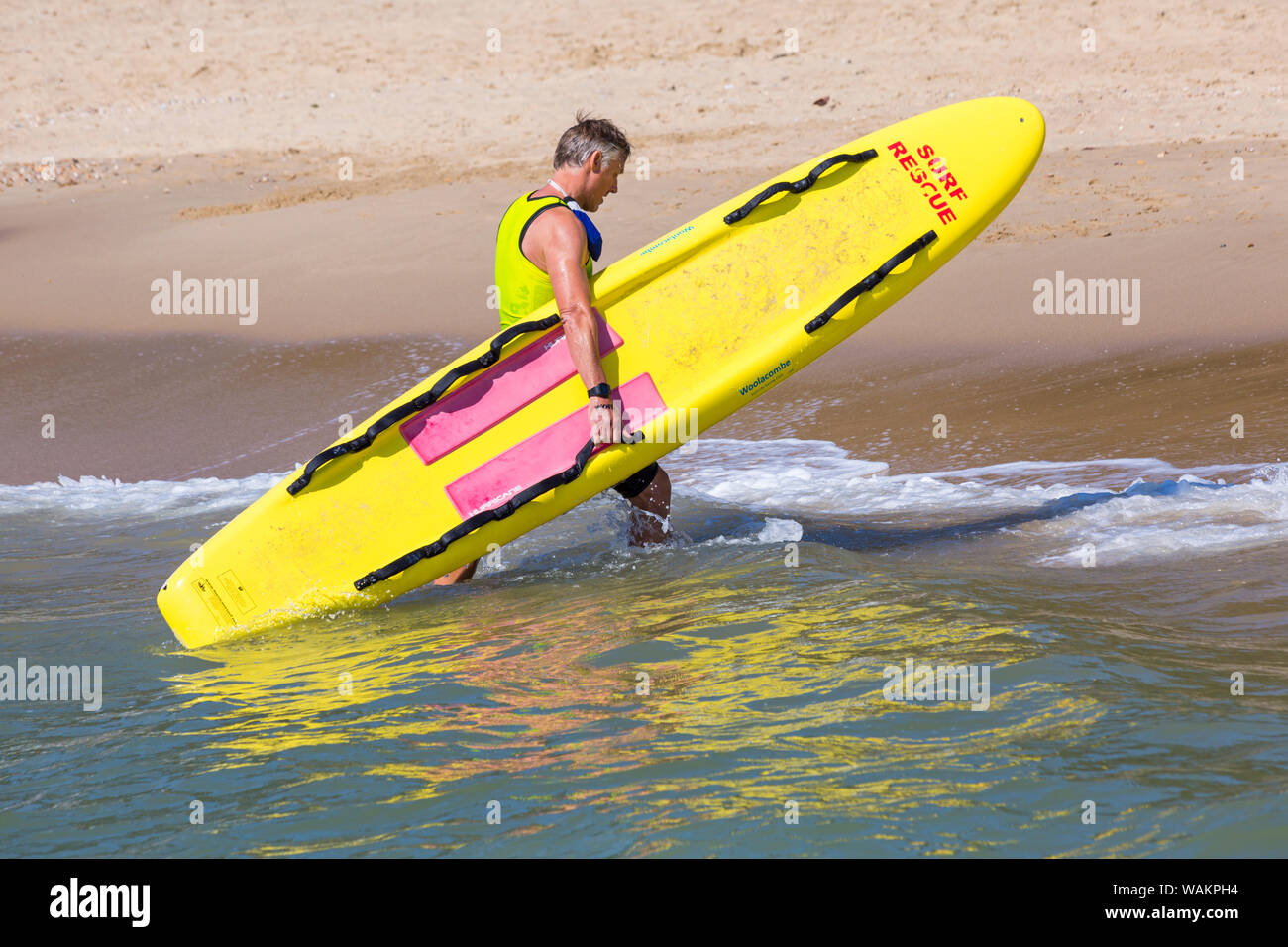 Rnli lifeguard carrying surf board hi-res stock photography and images ...