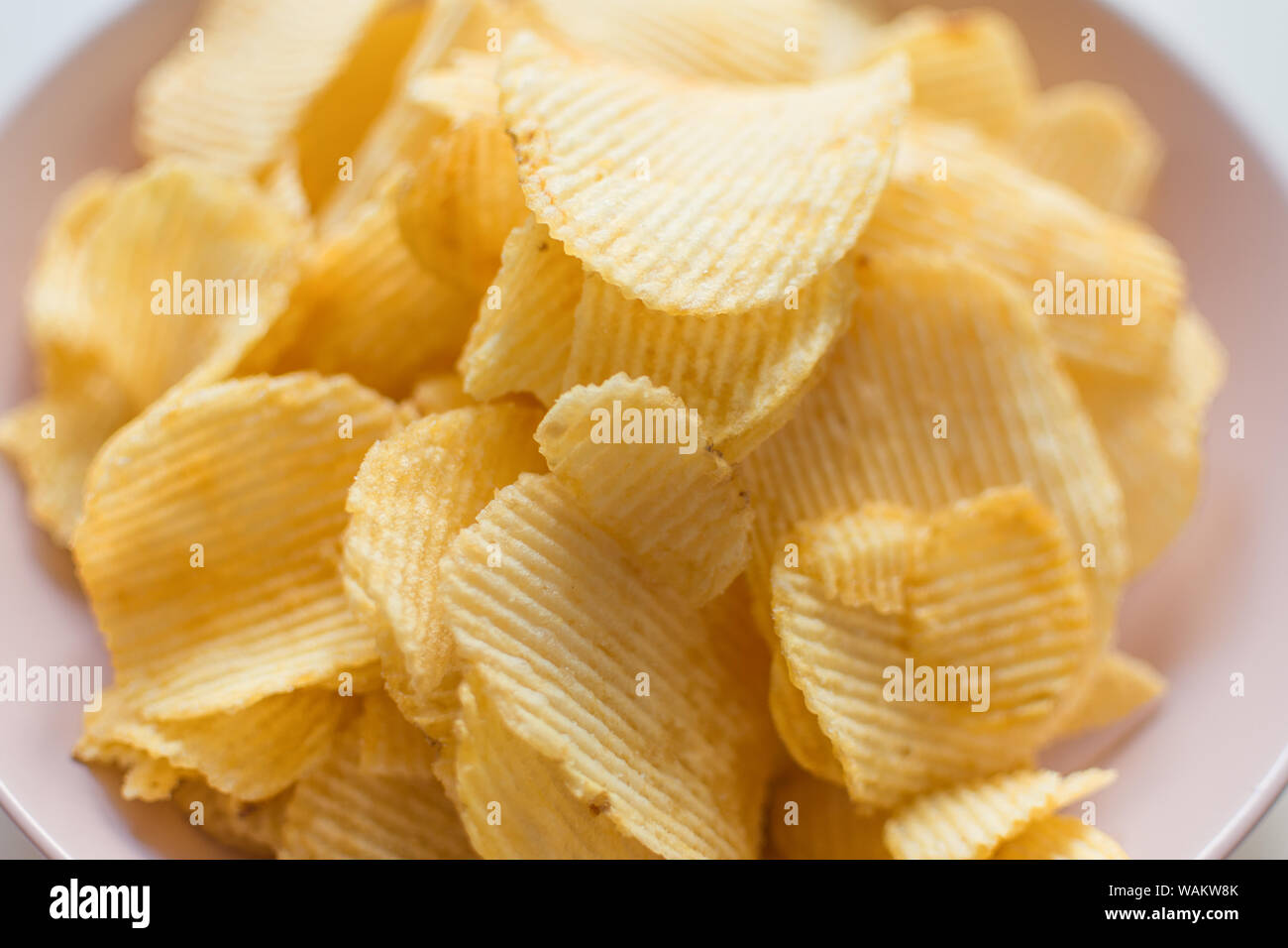 Heap of ribbed potato crisps. Potato chips, unhealthy eatting Stock